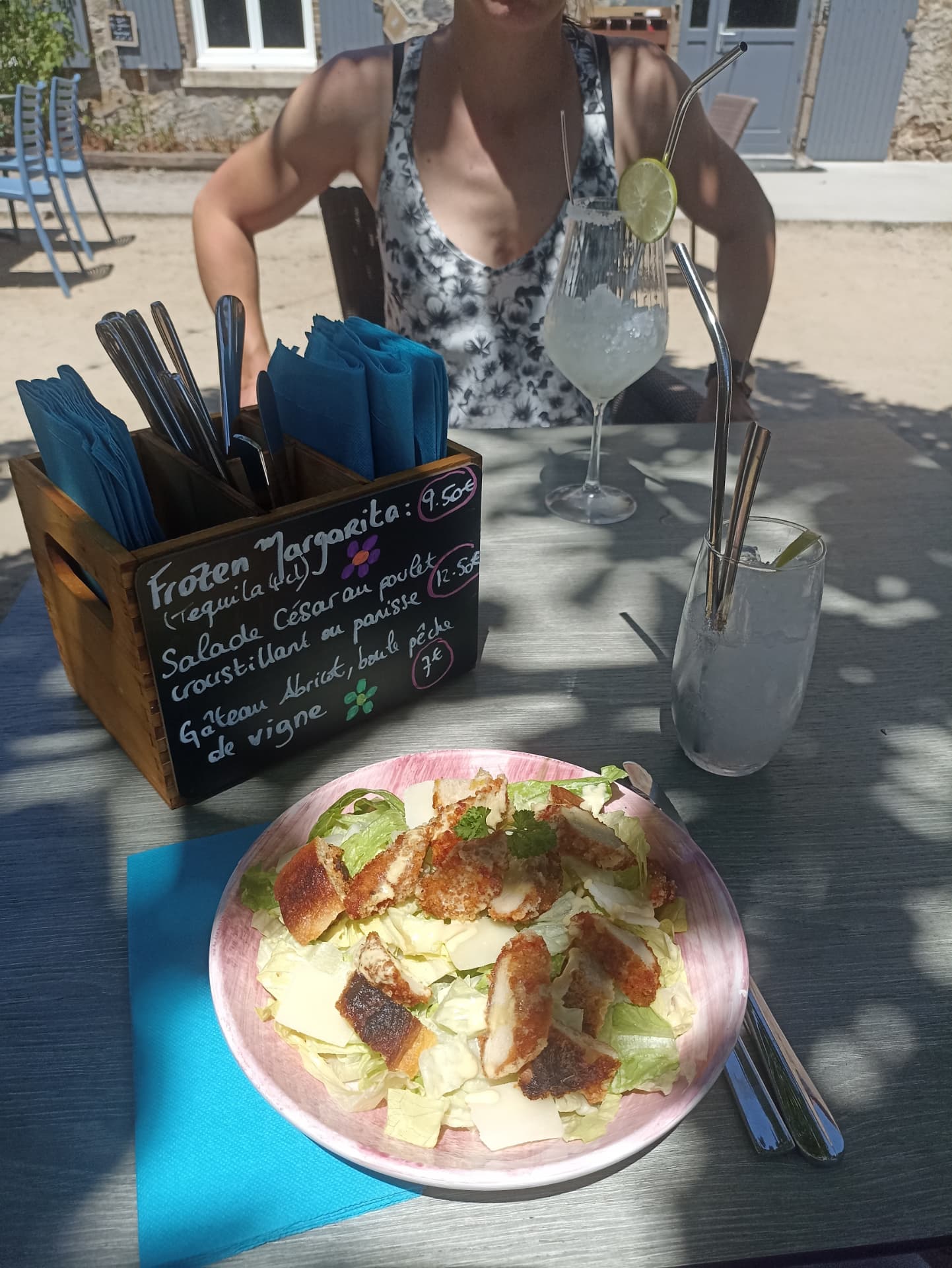 Salade César au poulet croustillant servie en terrasse au soleil