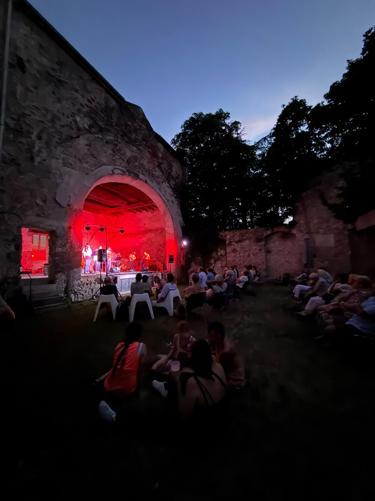Concert sous l'arche en pierre à la tombée de la nuit