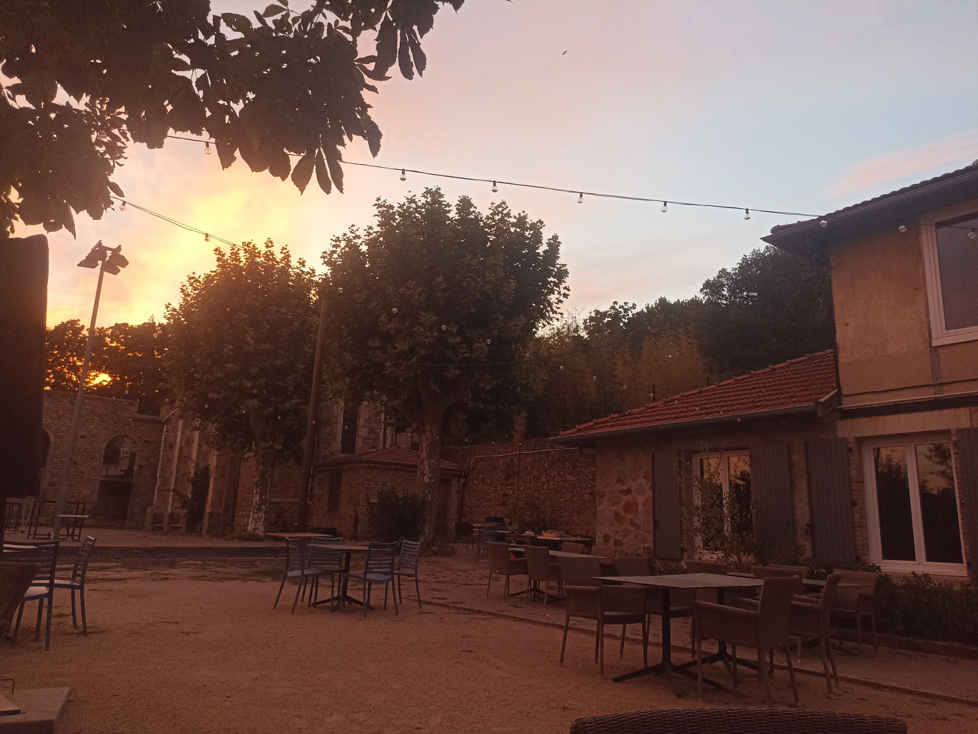 Terrasse du Cercle de Paras au coucher du soleil, guirlandes lumineuses et tables dressées
