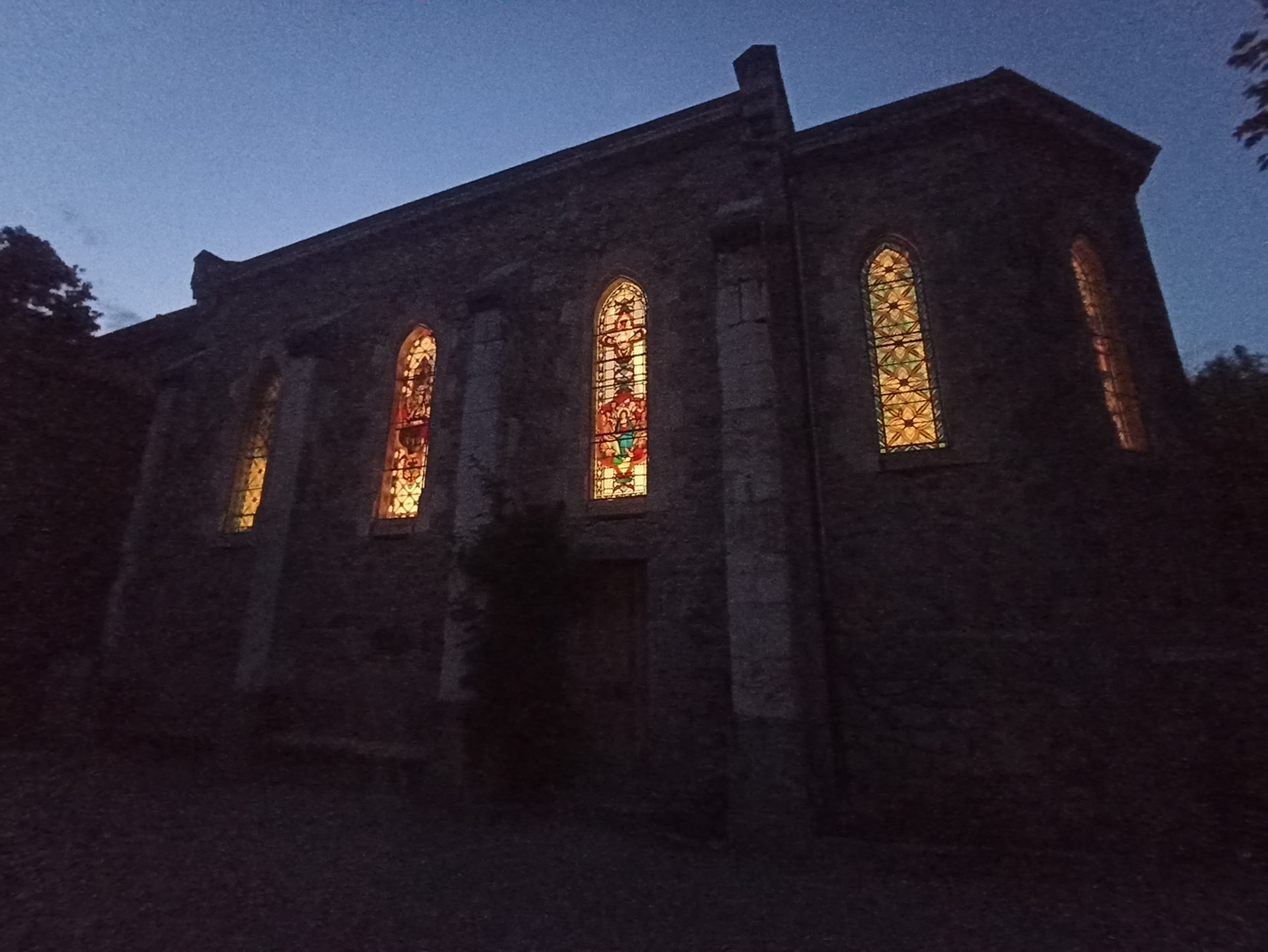 Les vitraux de la chapelle illuminés à la tombée de la nuit